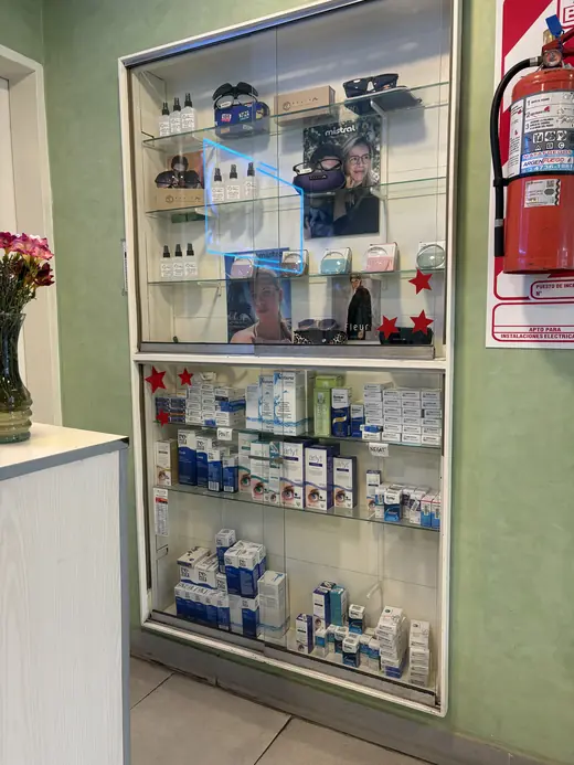 Vitrina de vidrio con anteojos de sol arriba y, abajo, cajas de lentes de contacto y líquidos
